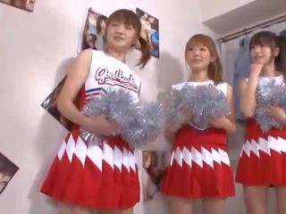 Kolme iso tiainen japanilainen cheerleaderit jakaminen kukko